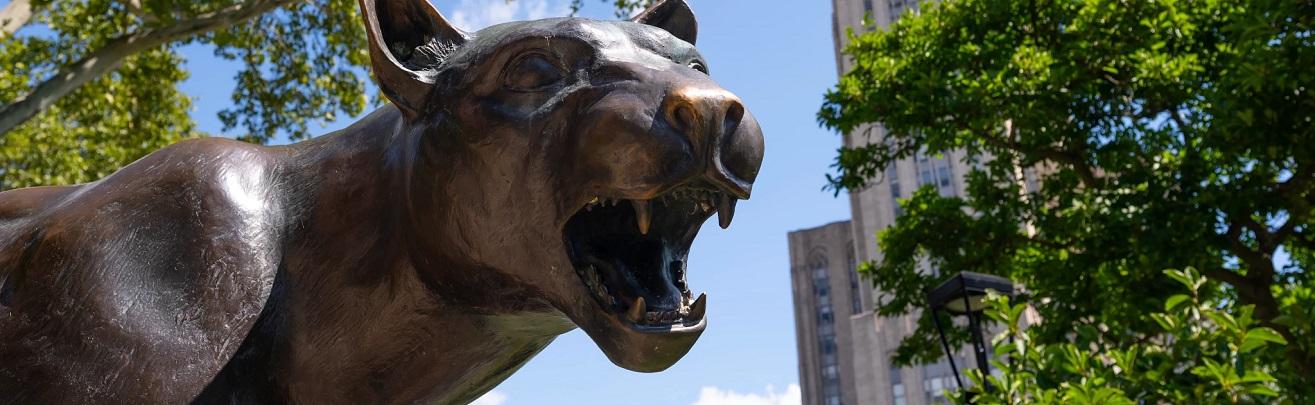 Image of the Panther statue with the Cathedral of Learning in the background